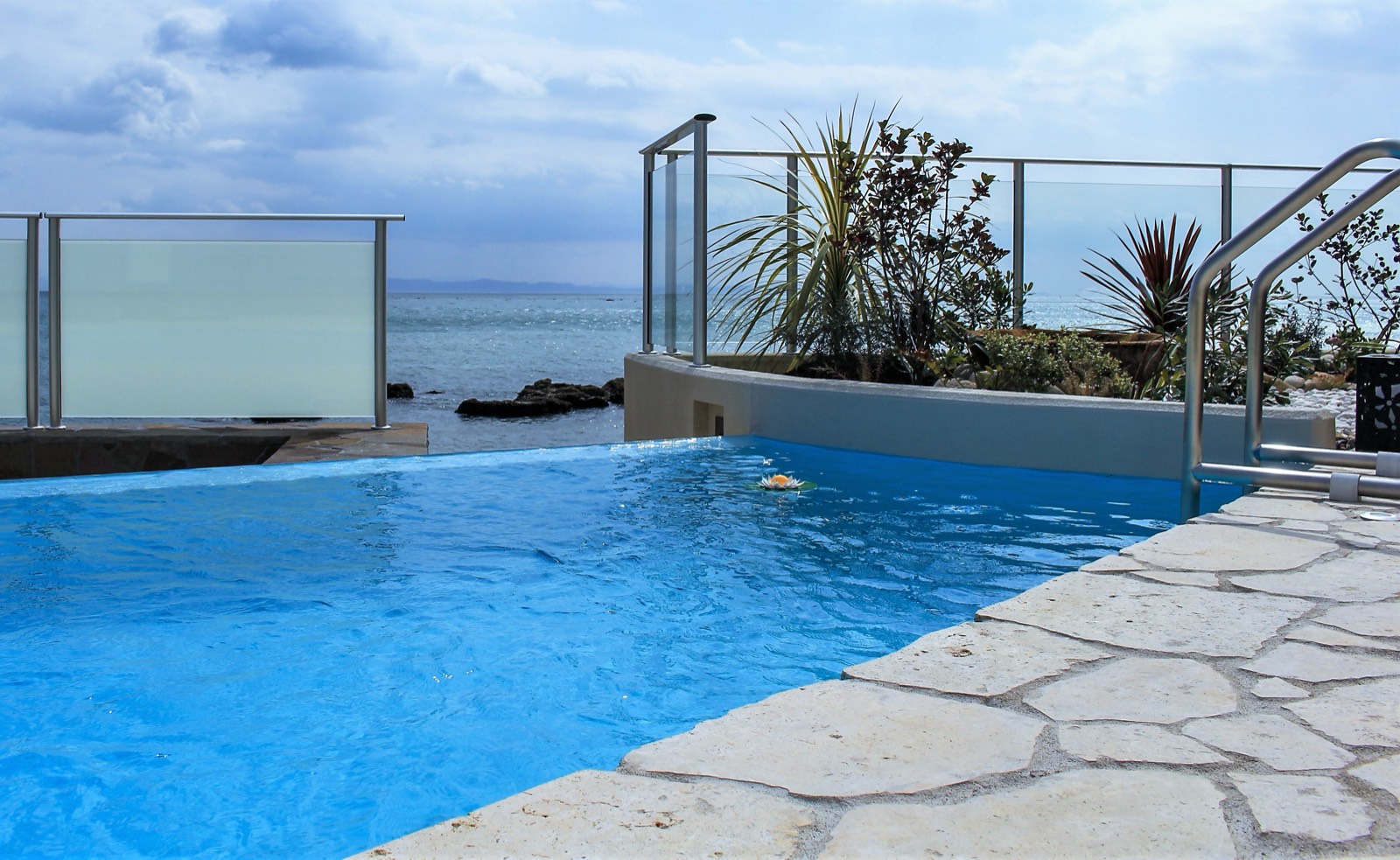 Piscine à débordement face à la mer, margelle en pierre